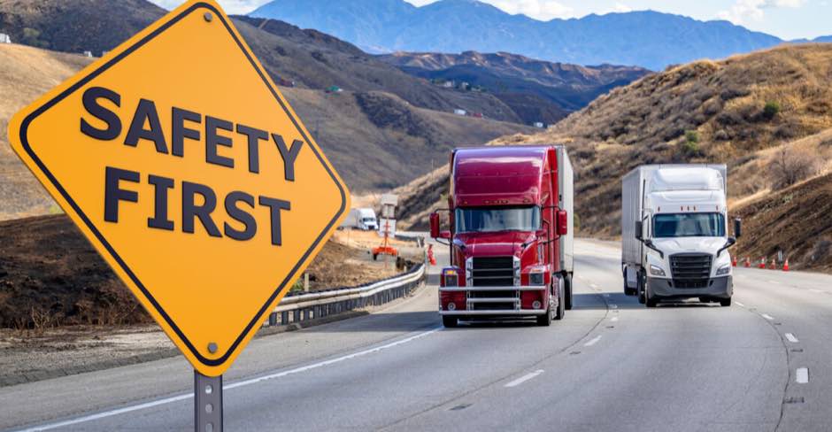 Safety First sign beside semi trucks on the highway